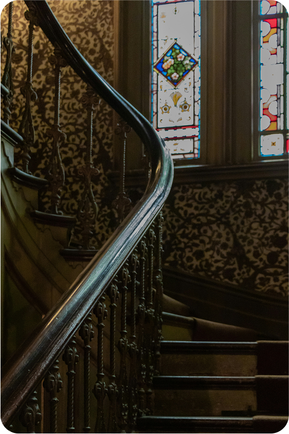 Elegant staircase and stained glass window representing heritage and legacy of Third Eye Investments